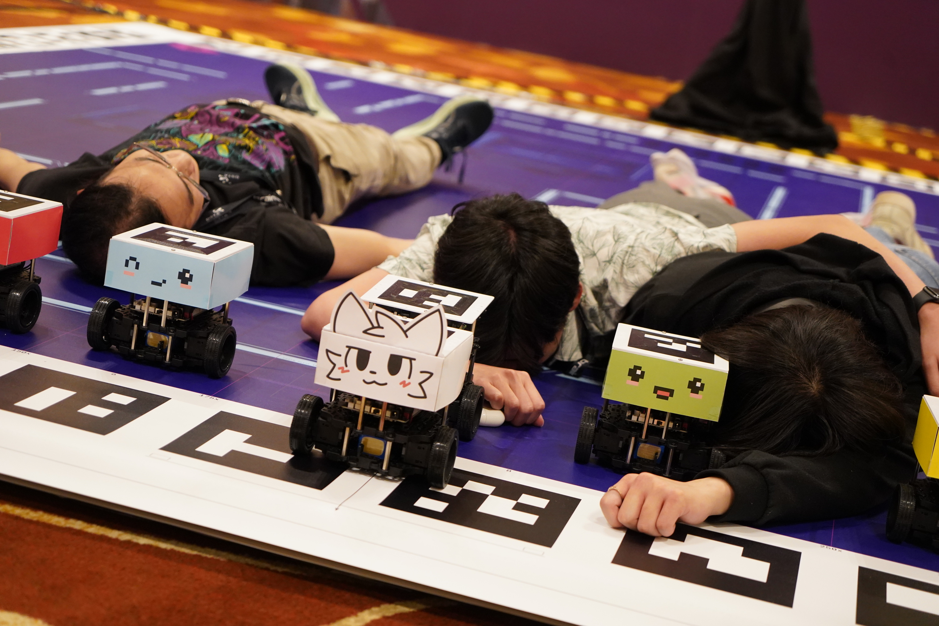 The tech team passed out on the Advanced Finals map post-event, alongside five tastefully decorated TurtleBot3 robots. From left to right: Ryan, Tianshi, me.